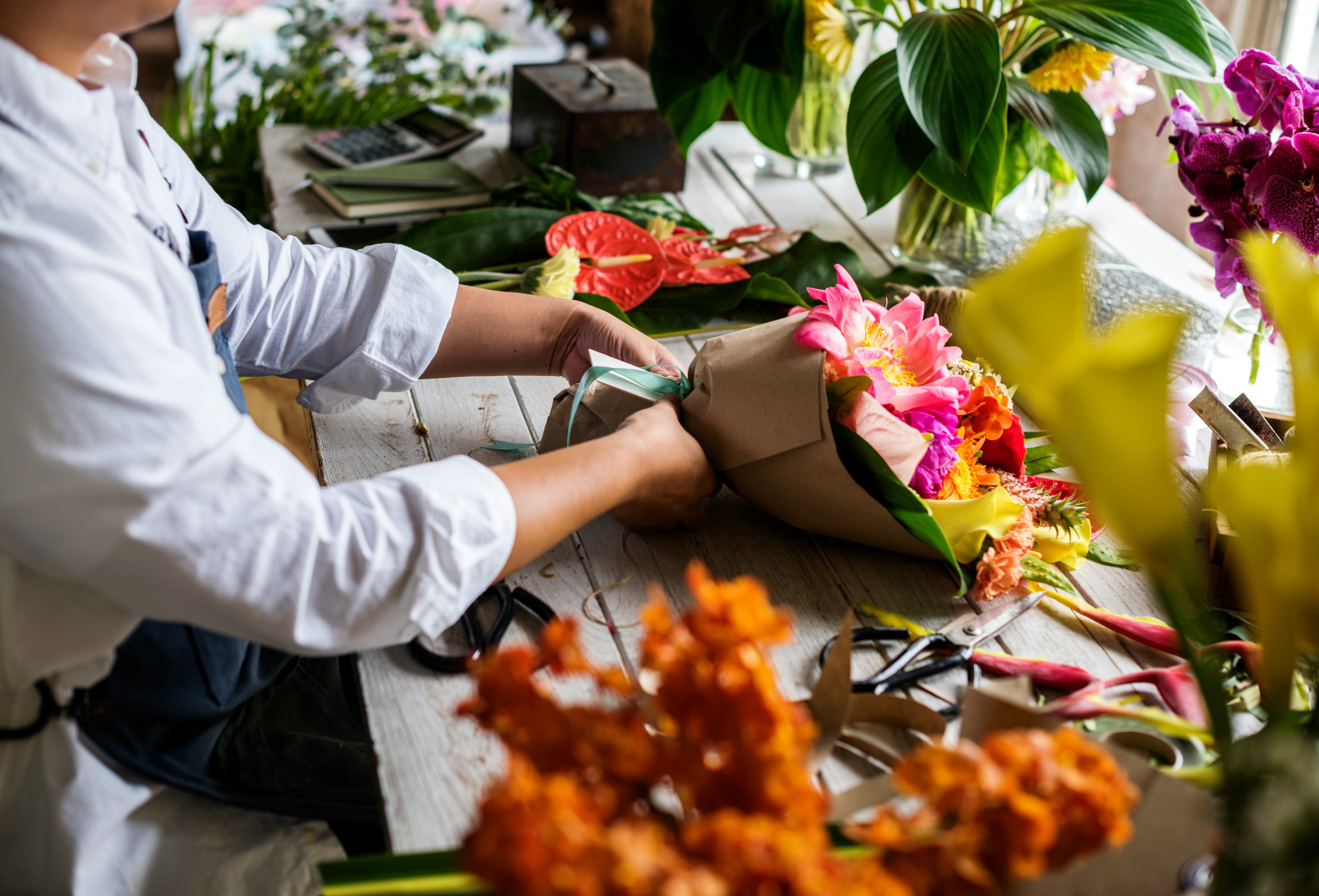 arms-of-a-person-wrapping-flowers-in-a-bouquet